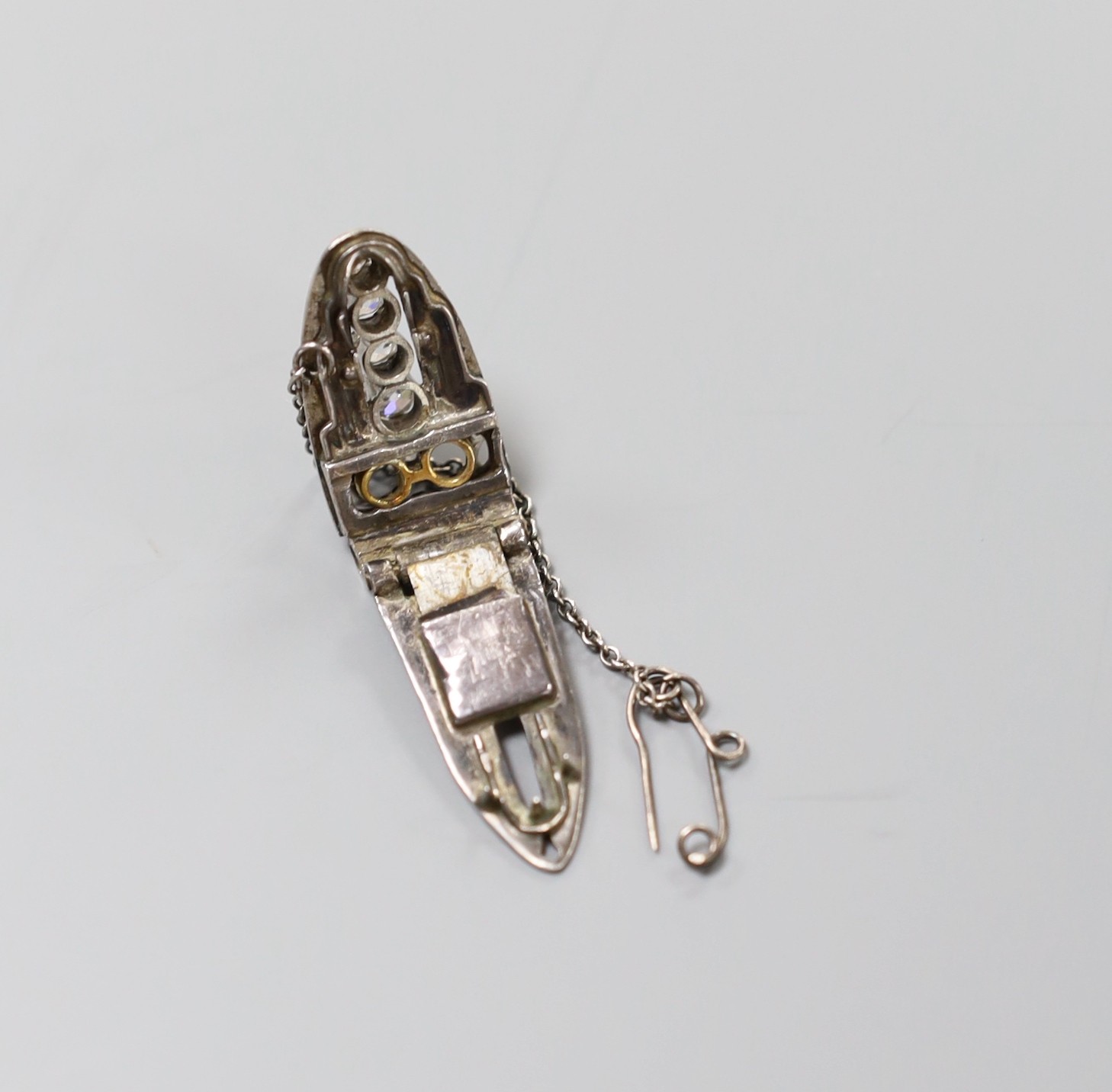 A white metal (stamped sterling silver) and graduated four stone diamond set clip brooch, 27mm, with two missing stones.